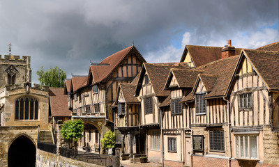 Fototapeta na wymiar Crooked Medieval tudor houses of Lord Leycester Hospital for ex-servicemen at Chapel of St James over West Gate on High Street Warwick England