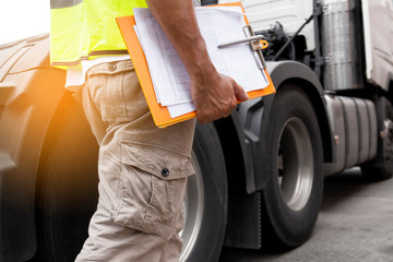 truck driver hand holding clipboard inspecting safety daily check before driving a truck. Auto...
