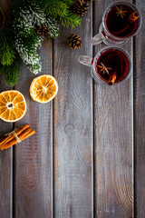 Mulled wine and fir branches frame on dark wooden background top view copy space