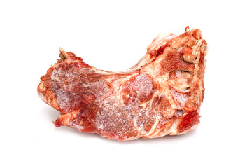 A piece of frozen meat is isolated on a white background. Beef steak on the bone.