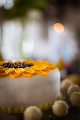Nahaufnahme einer Kokostorte mit Sonnenblumenmotiv aud Fondant
