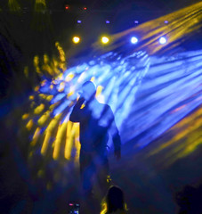 Blurred background to place text. Blurred Music Festival Background of a large hip hop concert in a nightclub. Bright stage lighting, a crowded dance floor with music lovers enjoy the show.