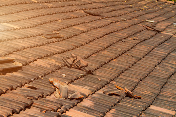 Broken old terracotta shingles on a roof, traditional cover in India, GOA, toned. Close up. Summer time. Textured background.