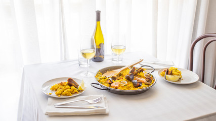 Restaurant Table with Spanish traditional dish. Seafood Paella with  prawns, clams, mussels on...