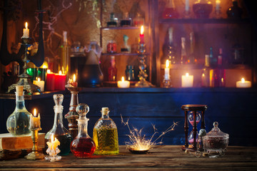 magic potions in bottles on wooden background - obrazy, fototapety, plakaty