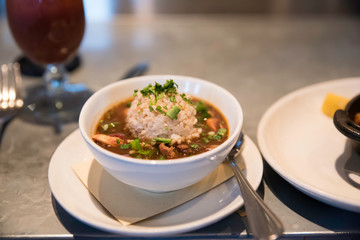 a close up of a bowl of cajun gumbo on the table ready for customers