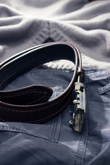 Close up of men's clothing and accessories. Jeans, a sweater and leather belt. Second-hand clothes or clothes shop fashion store. Banner for clothes shop