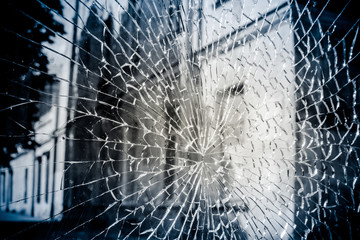 The glass is cracked. Through the glass you can see the street with houses