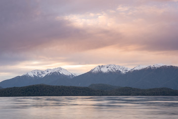 Fototapeta na wymiar Pink skies at sunset by the Southern alps glacial lake