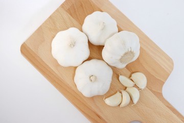 top view organic bulb garlic and clove on wooden chopping block with black background, have space for text.