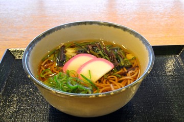 山菜とかまぼことネギが入った温かい蕎麦です