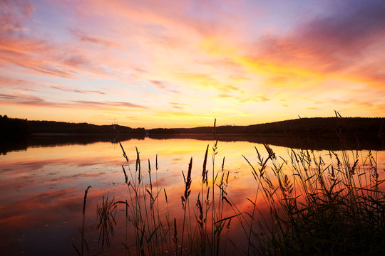 Summer Sunset On Lakeside With Reflection At Water