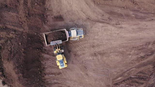 Excavator loading soil onto an Articulated hauler Truck, Top down aerial image.