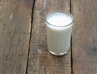 A cup of kefir on wooden background