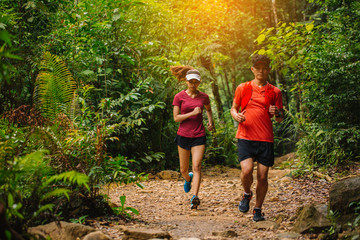 Runners. Young people  trail running on a mountain path. Adventure trail running on a mountain. Athletic attractive people running enjoying the sun exercising their healthy lifestyle.