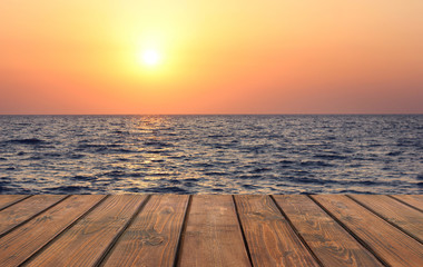 Empty wooden table against the sunset on the sea.