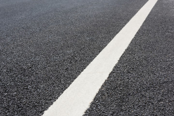 A white paint on a clean and tidy black asphalt road slash low angle close-up space background