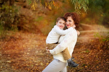 Happy family mother and son have fun in the park for a walk and hug each other.