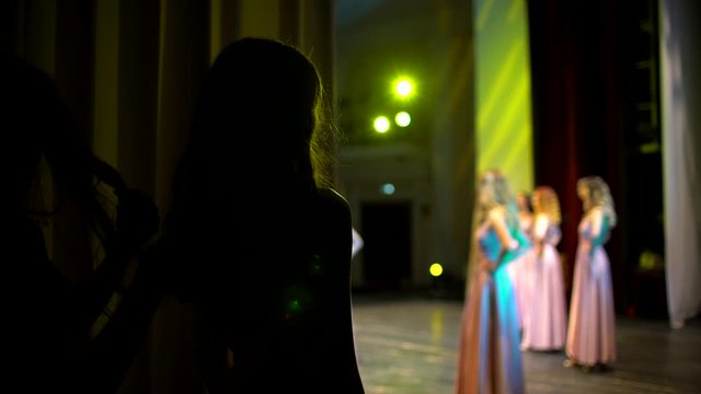 beauty contest. model backstage posing on stage. Woman female girl model actress in stylish dresses of designer standing on stage. theater scene perfomance, silhouette, singer, fashion show podium
