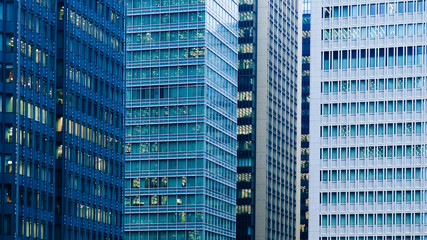 Fototapeta premium Marunouchi District modern office skyscraper glass wall buildings Tokyo downtown cityscape in evening with offices light on. Japan