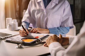  Medicine doctor hand working with modern computer and smart phone,digital tablet with his team on white desk as medical concept in morning light