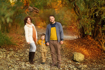 happy family mom dad and son on a walk in the autumn in the park
