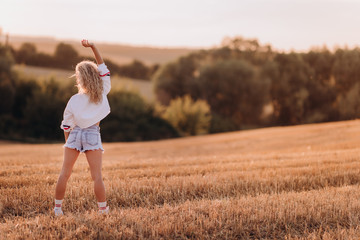 girl doing sports workout in a large meadow in the evening at sunset