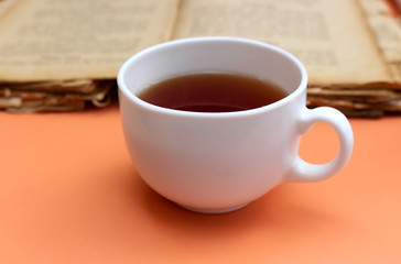 Autumn breakfast in garden. Cup of tea and old book.