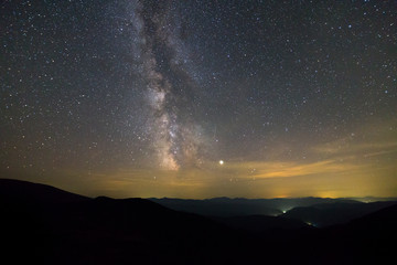 Night landscape of mountains with stars covered sky .