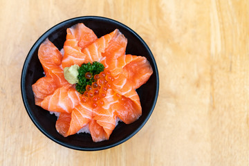Top view of salmon don, fresh sashimi, raw salmon, salmon roe , wasabi on wooden table. Copy space