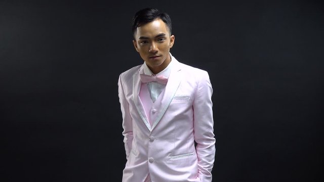 Young man in a pink suit is ready for prom night, a date, party or to go to a nightclub or event