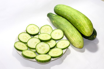 Cucumber slices put on a plate in a white background