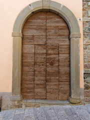 old wooden door on the wall of an italian house