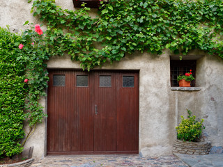 Fototapeta na wymiar old wooden door on the wall of an italian house