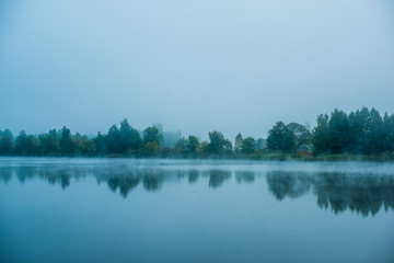 Blue fog on a river, autumn landscape 