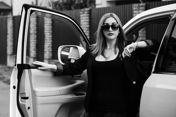 Business woman in a car, auto lady concept. Stylish lady in black jacket and glasses 
