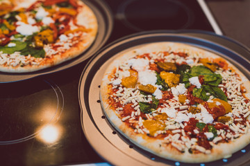 frozen vegetarian pizzas on stove about to be cooked in the oven