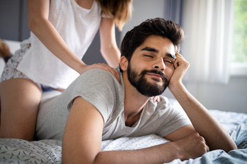 Cheerful young couple making massage at home