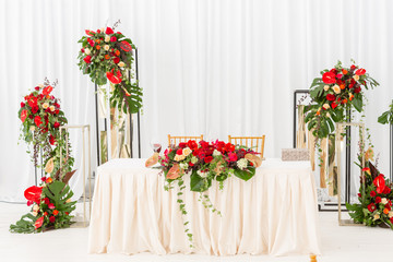 Fototapeta na wymiar Red decor theme. Beautiful banquet a wedding reception. Interior of a wedding tent decoration ready for guests. Decor flowers.