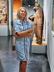 Mature woman visitor in the historical museum looking at pictures