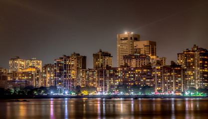 Obraz premium Hipnotyzujące zdjęcie Colaba Skyline w nocy, widziane z Nariman Point of Marine Drive. Budynki, pobocza i nocny targ Odbicia światła można zobaczyć na spokojnym Morzu Arabskim, jest jak wiśnia na szczycie