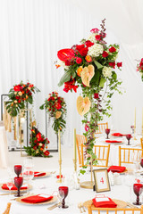 Red decor theme. Beautiful banquet a wedding reception. Interior of a wedding tent decoration ready for guests. Decor flowers.