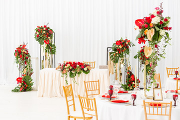 Red decor theme. Beautiful banquet a wedding reception. Interior of a wedding tent decoration ready for guests. Decor flowers.