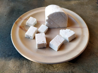 fresh cheese slice put in a plate isolated on stone background