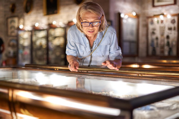 Woman visitor in the historical museum looking at art object.