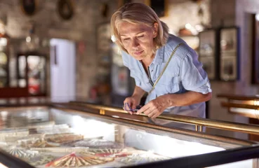 Foto op Plexiglas Woman visitor in the historical museum looking at art object. © JENOCHE