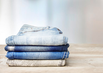  Pile of jeans on a wooden table