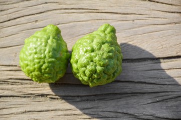 fresh green kiffir lime fruit on wooden board