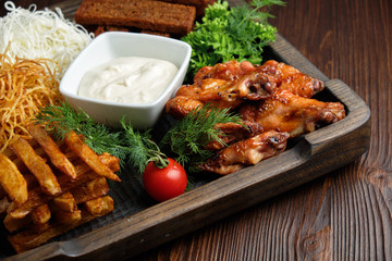 Hot appetizer on a wooden black plate on a dark wooden background. Restaurant menu