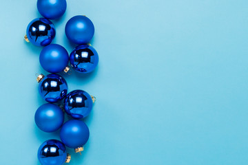 Blue Christmas tree toys, balls on a blue background. Concept of Merry Christmas and Happy New Year. Flat lay, top view. Copy space